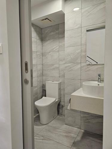 a bathroom with a toilet and a sink at Arte Cheras The Premium Suites by iLuxHome in Kuala Lumpur