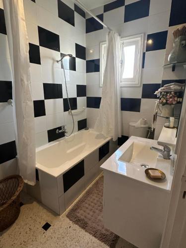 a bathroom with a black and white checkered wall at Luxeux et Idéal à Marsa Plage vue sur Mer in La Marsa