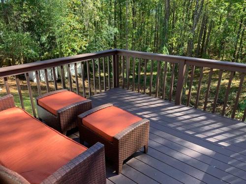 a wooden deck with two chairs and tables on it at At Home by Mall of GA! in Buford