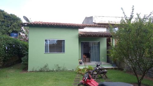 una casa verde con una moto aparcada frente a ella en Casa Flor en Antônio Cipriano