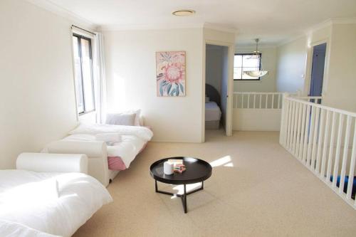 a living room with a couch and a table at Sunny & Spacious Family Retreat in Prestons