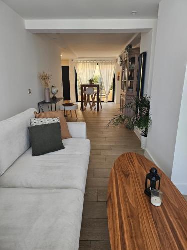- un salon avec un canapé blanc et une table en bois dans l'établissement Très grand deux pièces Marines de Cogolin, à Cogolin