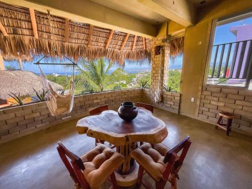 een eetkamer met een tafel en stoelen en een raam bij Villa Macarena Apartamentos Boutique - Adults Only in Puerto Escondido