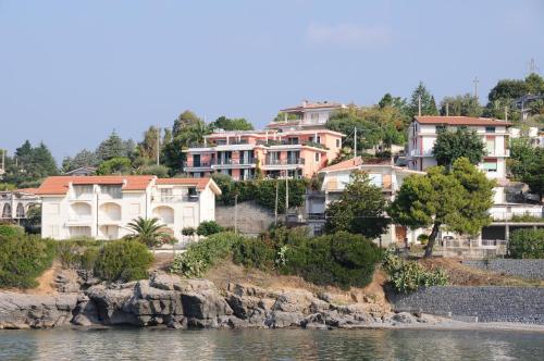 un grupo de casas en una colina junto al agua en La Cycas, en Villammare
