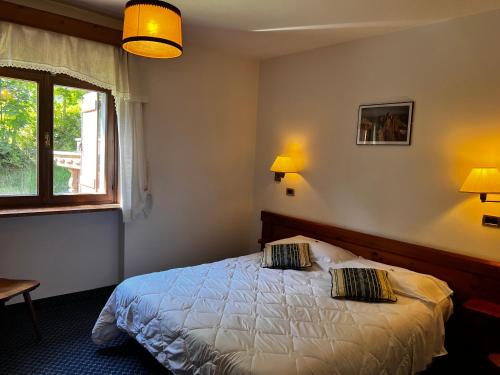 ein Schlafzimmer mit einem Bett mit zwei Kissen darauf in der Unterkunft HOTEL BRUSTOLON in Dont