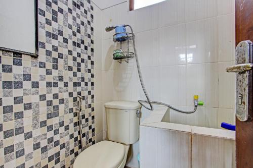 a bathroom with a toilet and a shower at SPOT ON 93006 Waithozz Bunkbeds in Yogyakarta