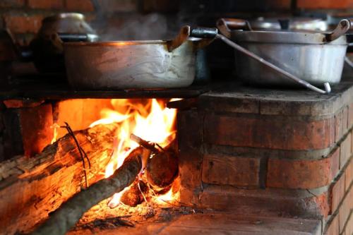 a stove with two pots and pans over a fire at Atma Anna in Piedade