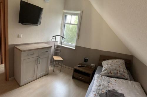 a bedroom with a bed and a sink and a window at Haus Seeblick Nr 48 in Geeste