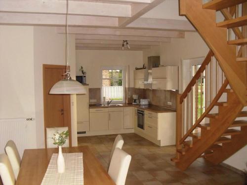 cocina y comedor con mesa y escalera en Haus Seeblick Nr 48, en Geeste