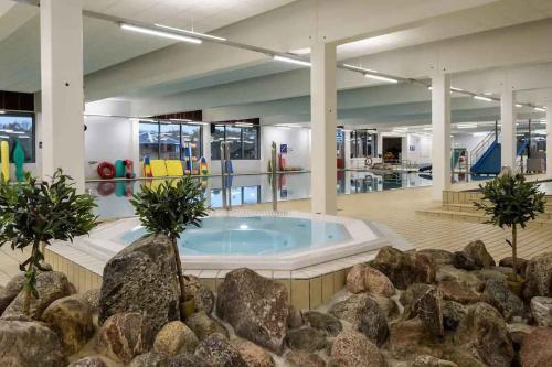 ein großes Schwimmbecken mit Felsen in einem Gebäude in der Unterkunft Vacation House In Arrild Ferieby in Toftlund