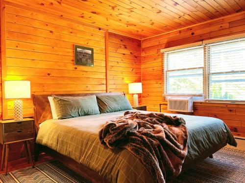 a bedroom with a bed in a wooden cabin at NewVida Preserve in Wilmington