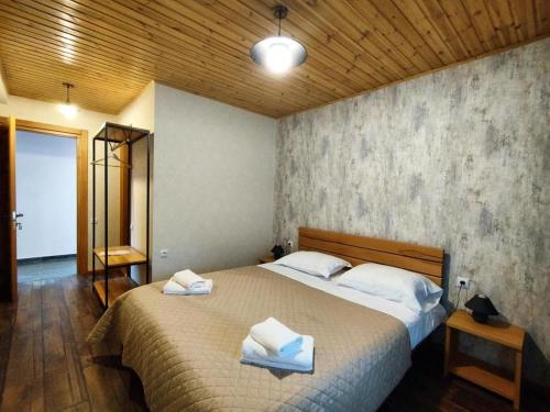 um quarto com uma cama grande e toalhas em Lastili Inn Hotel em Mestia