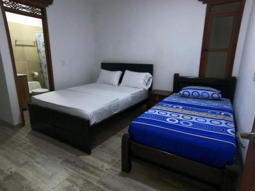 Habitación pequeña con 2 camas y ducha. en Balcones de la Rivera Apartamento Azulejo 3, en Buga