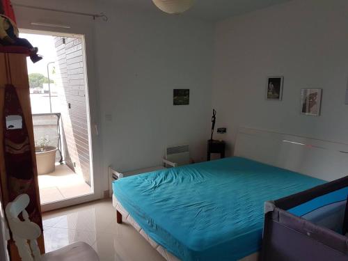 une chambre avec un lit et une grande fenêtre dans l'établissement Location saisonnière Résidence Ephyra Gruissan, à Gruissan