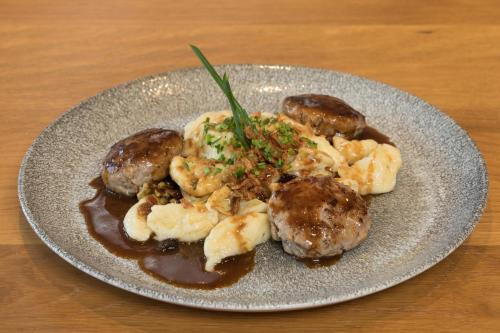 a plate of food with meat and potatoes on a table at Boutique-Hotel Vincenz in Brigels