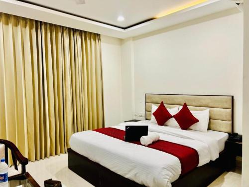 una camera da letto con un grande letto con cuscini rossi di Stay @Northview park hotel zirakpur a Zirakpur