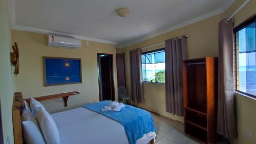 a bedroom with a bed with a teddy bear on it at Fabika Pousada in Maragogi