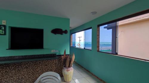 ein Badezimmer mit Toilette und Flachbildfernseher in der Unterkunft Fabika Pousada in Maragogi