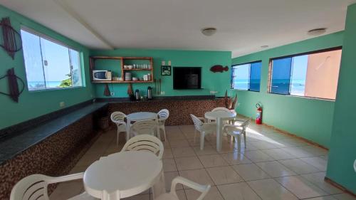 a restaurant with green walls and white tables and chairs at Fabika Pousada in Maragogi