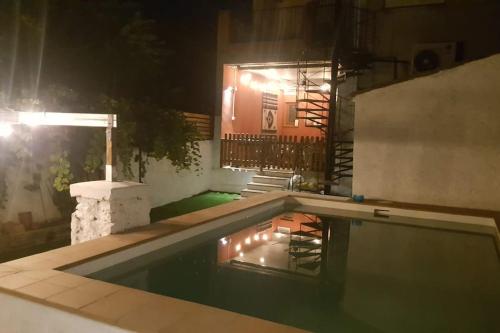 a swimming pool at night with a light in the water at Casa Rural La Garnacha in Alpera