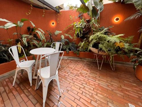 Un patio con mesa y sillas y plantas. en Hojarasca by Wynwood House, en Medellín