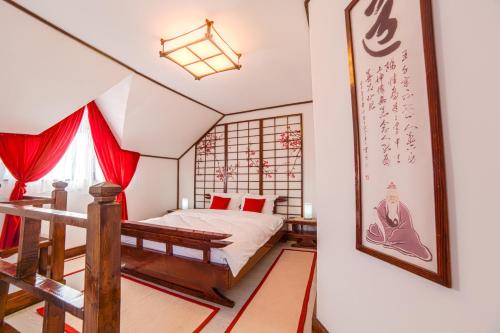 a bedroom with a bed with red curtains at Casa Lily - Japanese Retreat in Sighişoara