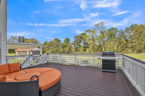 a deck with a grill and a couch and a table at Bull Run Estate- Luxury Retreat with Scenic Views home in Haymarket