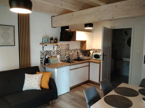 uma cozinha e sala de estar com um sofá e uma mesa em Apartamenty Równia 2 em Ustrzyki Dolne