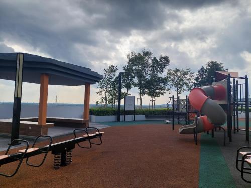a park with a playground with a slide and benches at KLIA Travel Homestay - 3R 2B - WIFI & NETFLIX in Sepang
