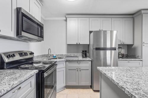 a kitchen with white cabinets and a stainless steel refrigerator at Quiet apartment in Iowa, LA in Iowa