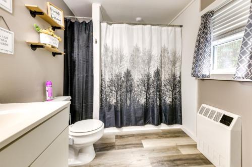 a bathroom with a toilet and a window with trees at Cozy Vermont Escape - Patio, Lake and Mountain Views in Barton