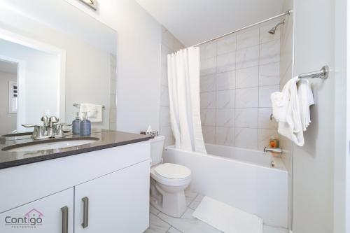 a white bathroom with a toilet and a sink at Orchards Retreat, AC, Family Friendly, Sleeps 10, NearAirprt in Nisku