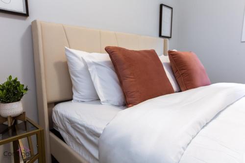 a bed with brown and white pillows on it at Orchards Retreat, AC, Family Friendly, Sleeps 10, NearAirprt in Nisku