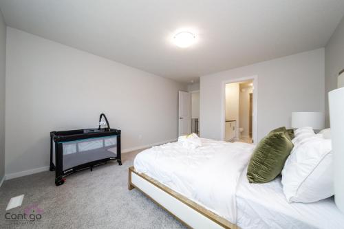 a bedroom with a white bed and a piano at Orchards Retreat, AC, Family Friendly, Sleeps 10, NearAirprt in Nisku