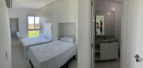 une petite chambre avec deux lits et un miroir dans l'établissement Muro Alto Club Risort, à Porto de Galinhas