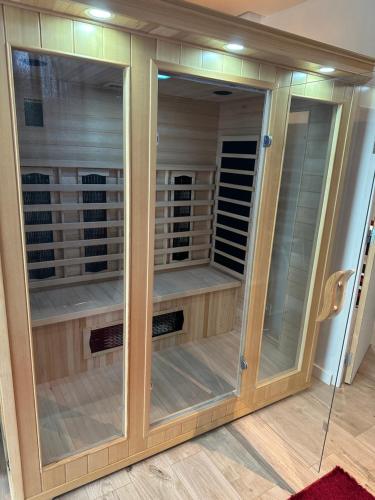 a large wooden cabinet with glass doors at Love Room 80m2 BDSM 50 nuances de Grey - SAUNA - Parking gratuit in Antibes