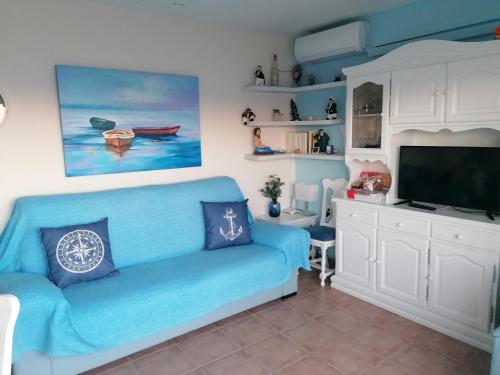 un soggiorno con divano blu e TV di apartamento junto al mar a Cullera