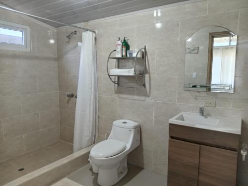 a bathroom with a toilet and a sink and a shower at Apartamentos Manik in Trujillo