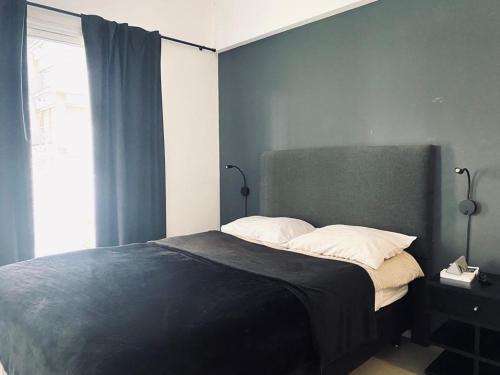 um quarto com uma cama com uma parede azul em Luxury apartment in Palermo em Buenos Aires