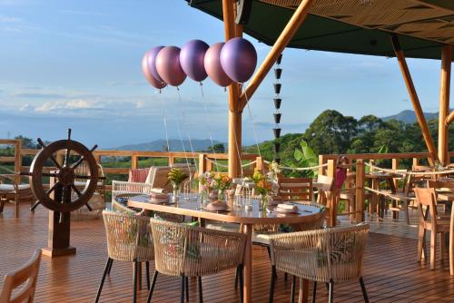a wooden deck with a wooden table and chairs at LA PERLA FINCA HOTEL in Gigante