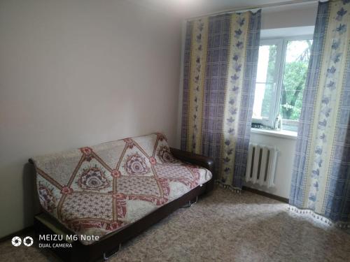 Cama en habitación con ventana en 1 комнатные апартаменты в районе Атакента, en Almaty