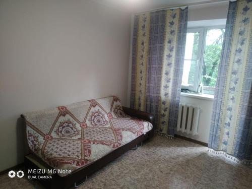 a bed in a room with a window at 1 комнатные апартаменты в районе Атакента in Almaty