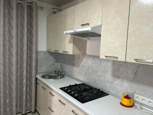 a kitchen with a sink and a stove top oven at "Lime" Aparthotel in Bukhara