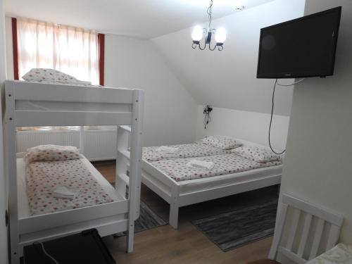 two bunk beds in a room with a flat screen tv at Skigyimes Guesthouse in Lunca de Sus