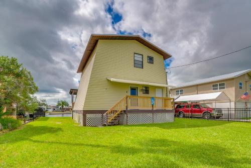 a yellow house with a porch and a yard at Hernando Beach Waterfront Home with Boat Dock and Deck in Hernando Beach