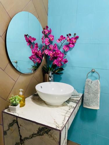 a bathroom with a sink and a mirror and flowers at Departamento centrico - Bufa House in Guanajuato