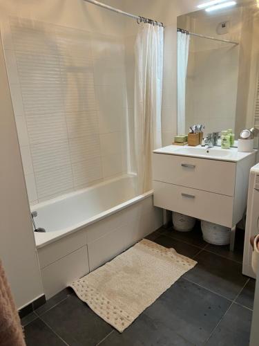 W łazience znajduje się biała wanna, umywalka i wanna tubermott. w obiekcie Chez moi à côté du Groupama stadium w mieście Décines-Charpieu