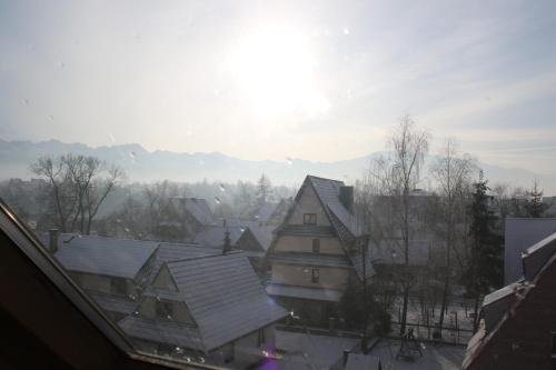 a view of a town with snow covered roofs at Pokoje Gościnne Łukaszczyk in Zakopane