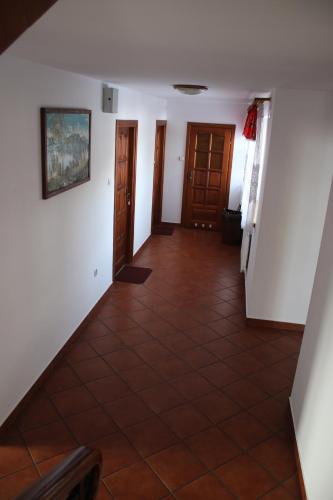 a hallway with white walls and a tile floor at Pokoje Gościnne Łukaszczyk in Zakopane