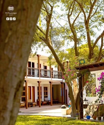 a large white house with a balcony and trees at Bodega el Huarango in Ica